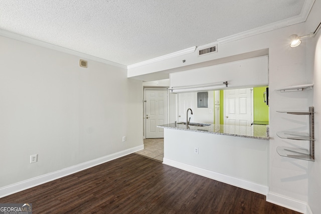 kitchen with sink, light stone counters, wood-type flooring, a textured ceiling, and white cabinets