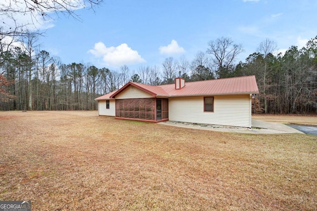 ranch-style home with a sunroom and a front lawn