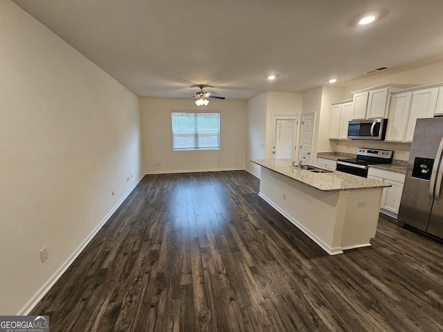 kitchen with appliances with stainless steel finishes, sink, a center island with sink, white cabinets, and dark hardwood / wood-style floors