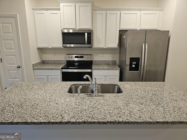 kitchen with white cabinetry, sink, stainless steel appliances, and light stone counters