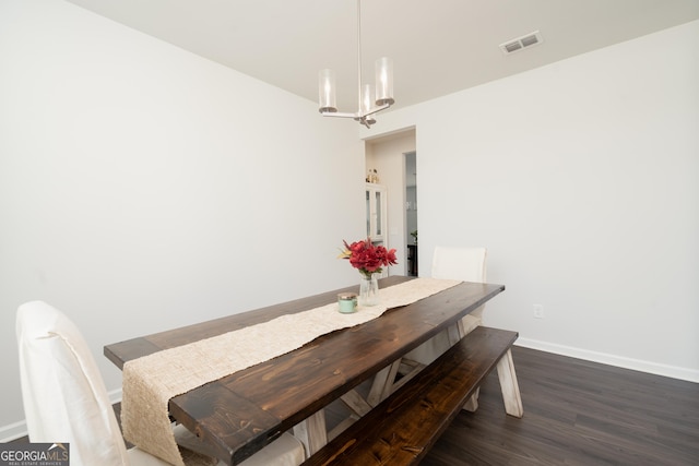 dining space with dark hardwood / wood-style flooring and a notable chandelier