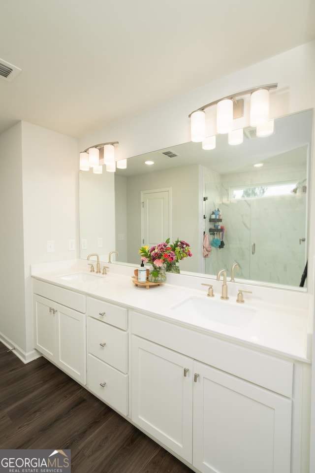 bathroom with vanity, an enclosed shower, and hardwood / wood-style flooring