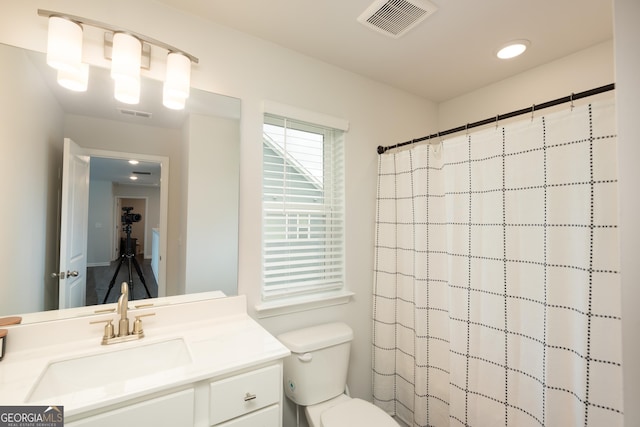 bathroom featuring a shower with curtain, vanity, and toilet