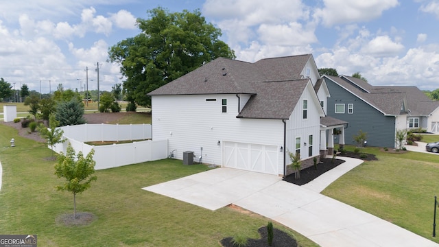 view of side of property featuring a garage, cooling unit, and a lawn