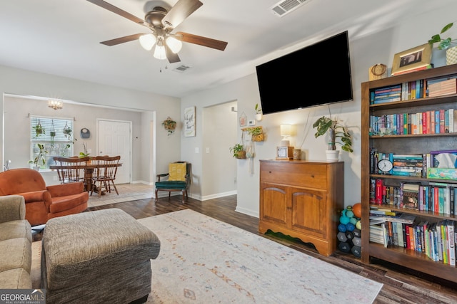 living room featuring ceiling fan and dark hardwood / wood-style flooring