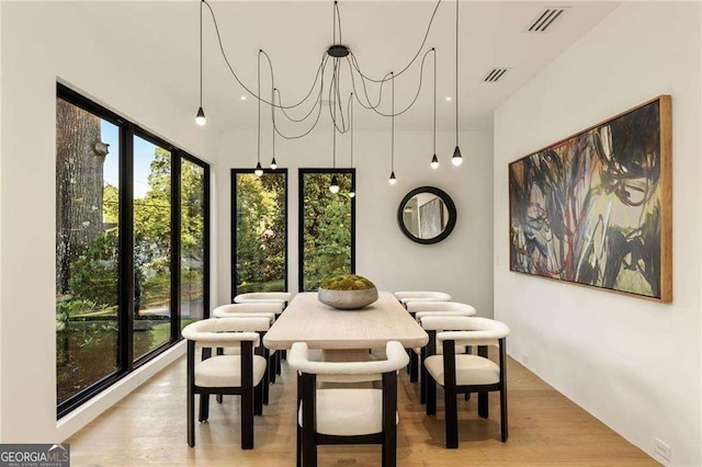 dining area with a chandelier and light hardwood / wood-style flooring