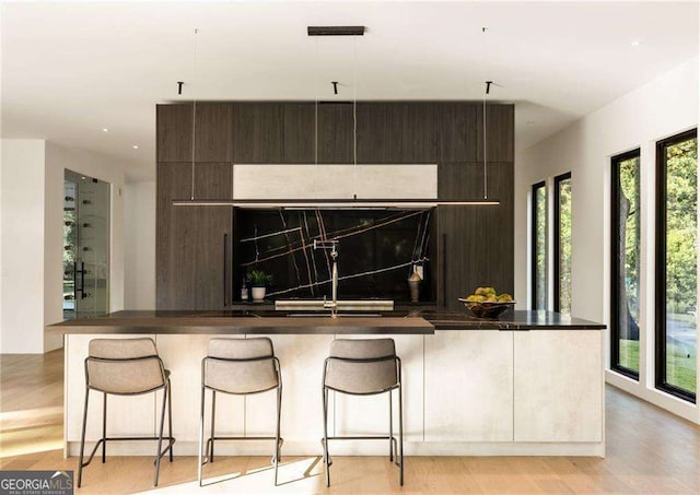 kitchen featuring a breakfast bar area, a kitchen island, and a healthy amount of sunlight