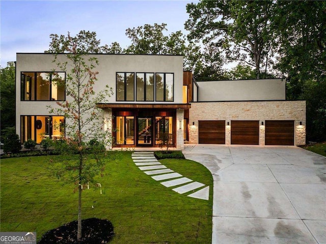 contemporary house with a porch, a garage, and a front lawn