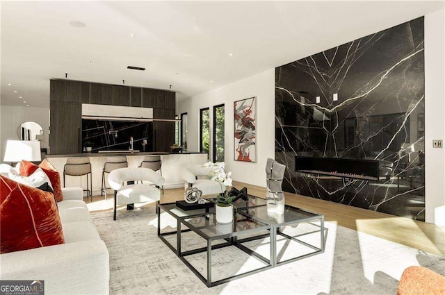 living room featuring a high end fireplace and tile walls