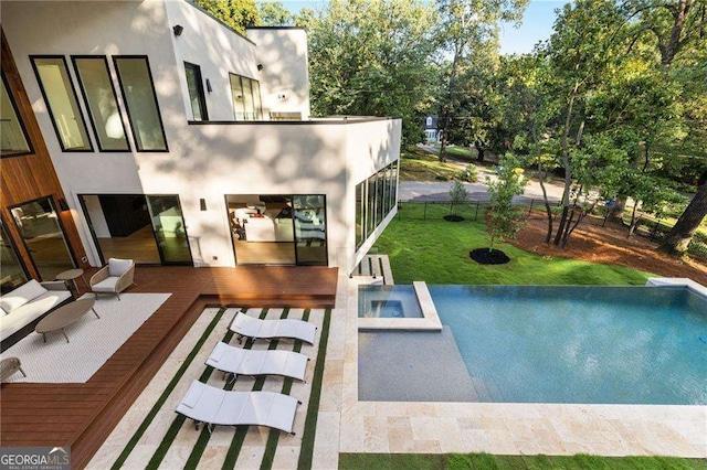 view of swimming pool featuring a deck, an in ground hot tub, and a yard