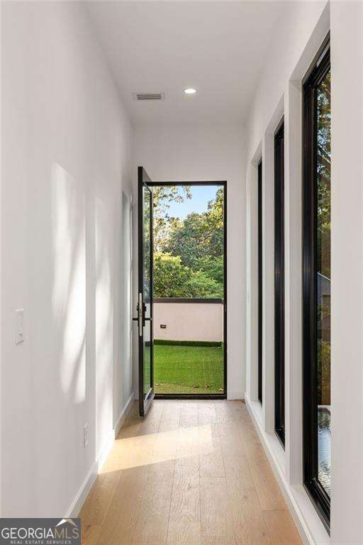 doorway to outside featuring a wealth of natural light and light hardwood / wood-style flooring