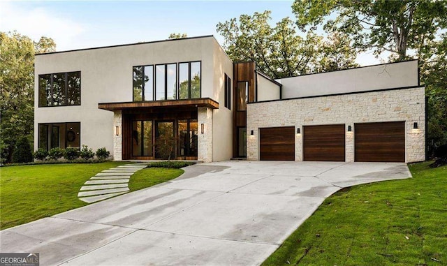 contemporary house featuring a garage and a front lawn