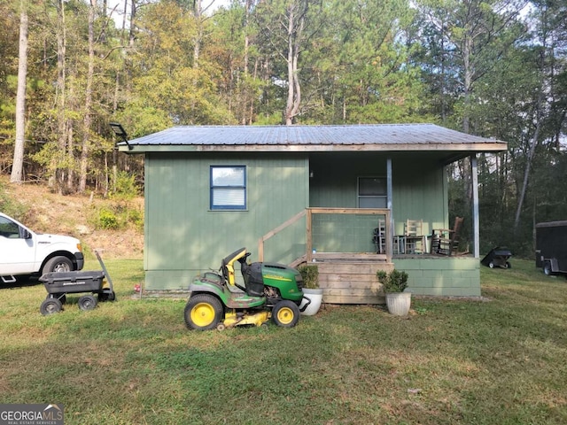 view of outdoor structure featuring covered porch and a yard