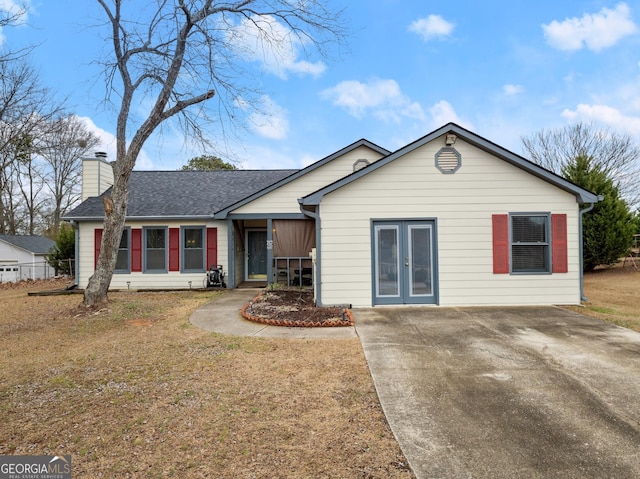 single story home with french doors and a front lawn