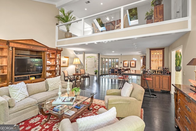 living room with dark hardwood / wood-style floors and a towering ceiling