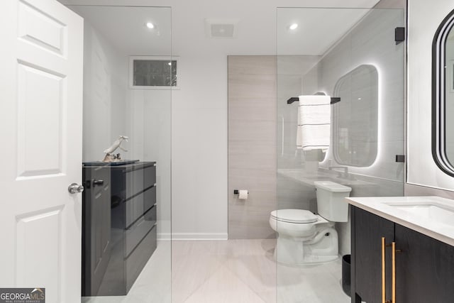 bathroom with tile patterned floors, vanity, tile walls, and toilet