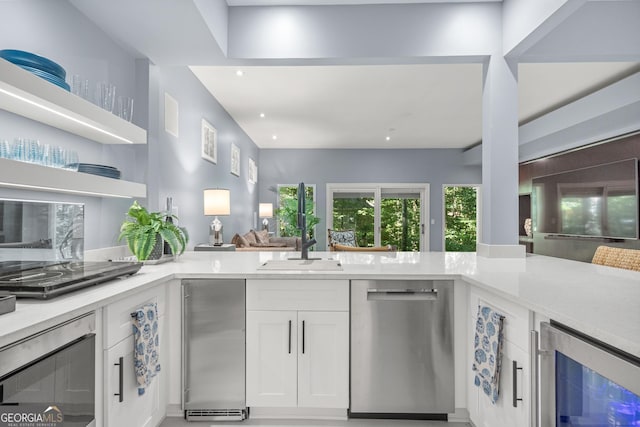 kitchen with wine cooler, white cabinetry, and stainless steel dishwasher