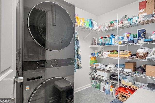 clothes washing area featuring stacked washer and clothes dryer