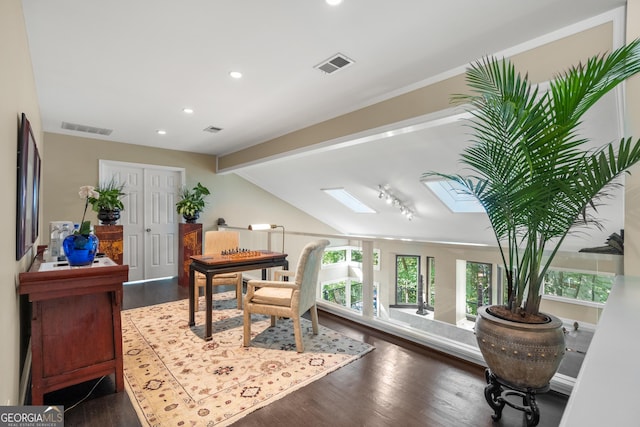 office space featuring dark hardwood / wood-style flooring and lofted ceiling with skylight