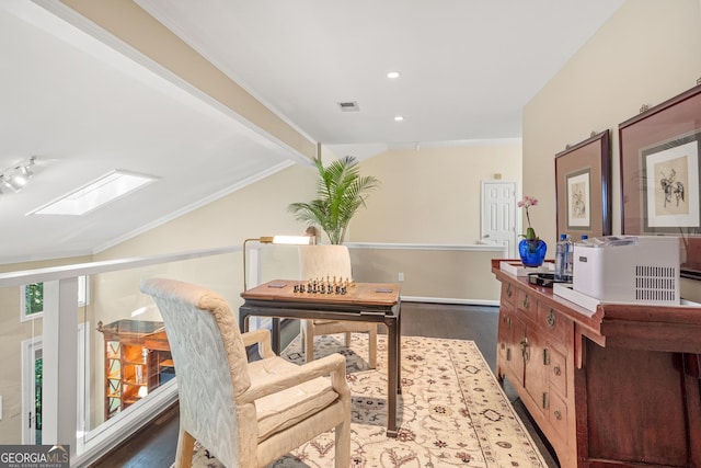 office space featuring wood-type flooring, lofted ceiling with skylight, and crown molding