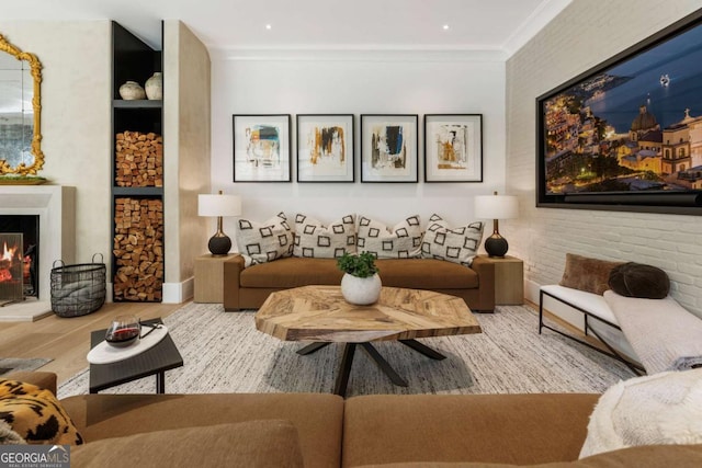 sitting room with hardwood / wood-style floors, crown molding, and brick wall