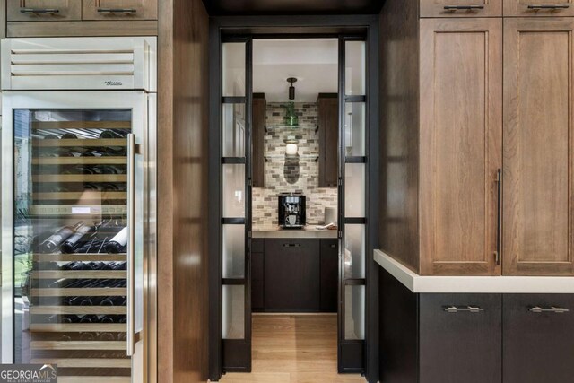 wine area featuring light hardwood / wood-style flooring and beverage cooler