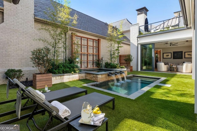 back of house featuring a lawn, pool water feature, a balcony, and a pool with hot tub