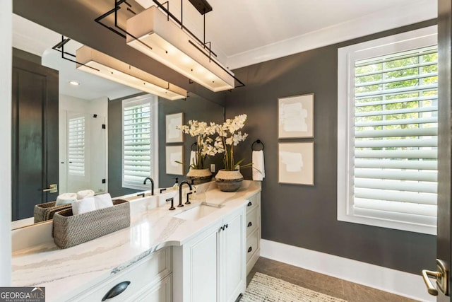 bathroom featuring tile patterned flooring, vanity, and crown molding