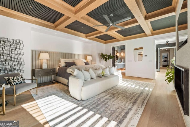 bedroom with beamed ceiling, light wood-type flooring, and coffered ceiling