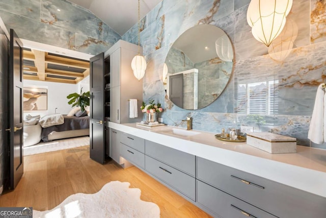 bathroom featuring coffered ceiling, vanity, beam ceiling, hardwood / wood-style flooring, and tile walls