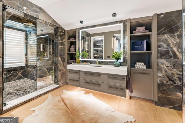 bathroom featuring wood-type flooring, vanity, vaulted ceiling, and an enclosed shower