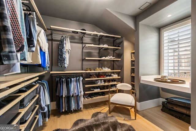 walk in closet with light hardwood / wood-style floors