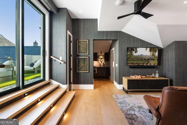 interior space with light wood-type flooring, vaulted ceiling, and ceiling fan