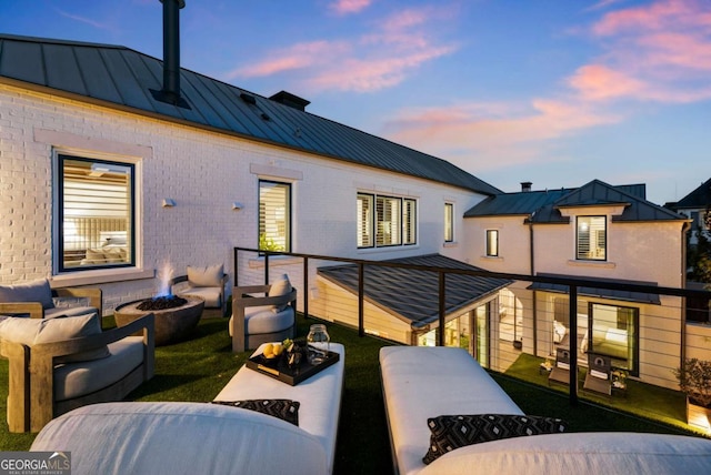 back house at dusk featuring an outdoor living space