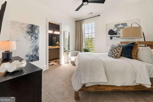 carpeted bedroom with ceiling fan and ensuite bath