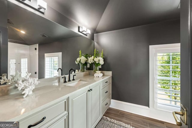 bathroom with vanity, plenty of natural light, and lofted ceiling