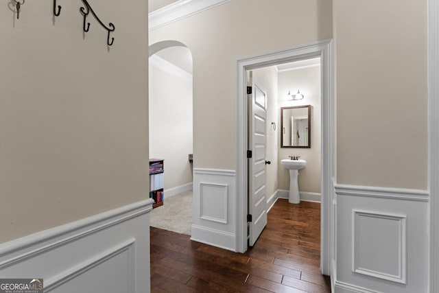 corridor with dark hardwood / wood-style flooring, crown molding, and sink