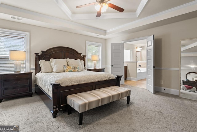 bedroom featuring ceiling fan, ensuite bathroom, light carpet, and multiple windows