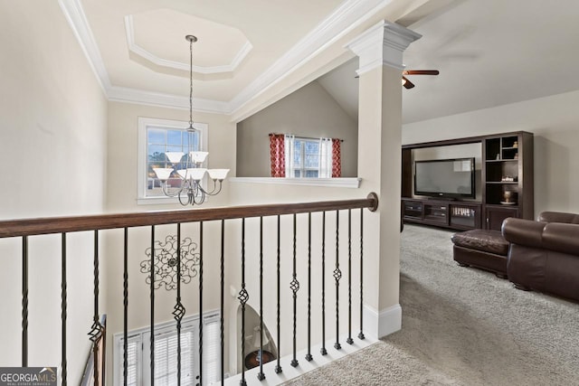 hallway featuring a tray ceiling, carpet floors, a chandelier, and ornamental molding