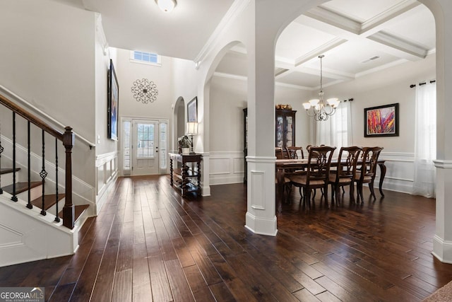 entryway with an inviting chandelier, beam ceiling, dark hardwood / wood-style flooring, and coffered ceiling