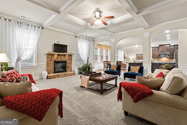 carpeted living room featuring ceiling fan, a fireplace, beamed ceiling, and coffered ceiling