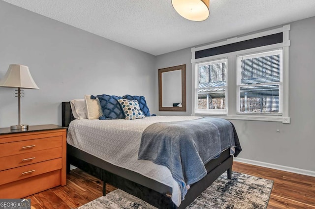 bedroom featuring dark hardwood / wood-style floors and a textured ceiling