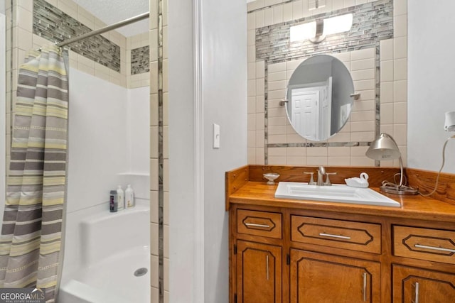 bathroom featuring decorative backsplash, a shower with curtain, vanity, and a textured ceiling