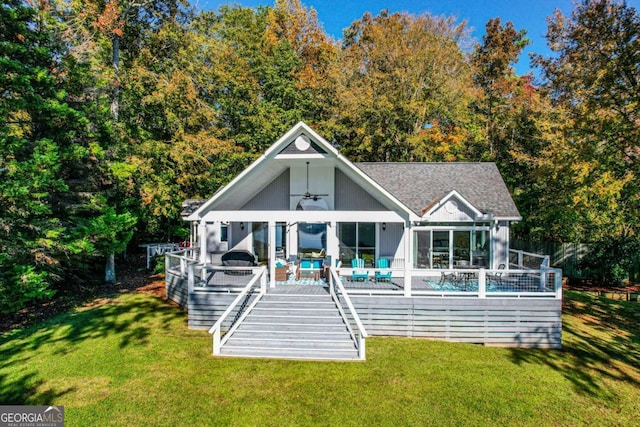 rear view of property with a yard, ceiling fan, a pool side deck, and a sunroom