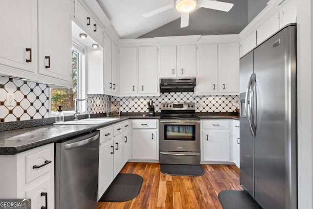 kitchen with hardwood / wood-style floors, sink, vaulted ceiling, white cabinetry, and stainless steel appliances