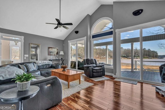 living room featuring a water view, ceiling fan, hardwood / wood-style floors, and high vaulted ceiling