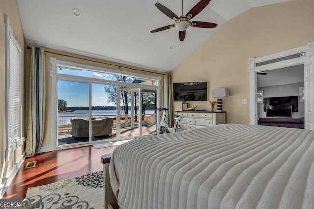 bedroom featuring hardwood / wood-style flooring, ceiling fan, access to exterior, and vaulted ceiling