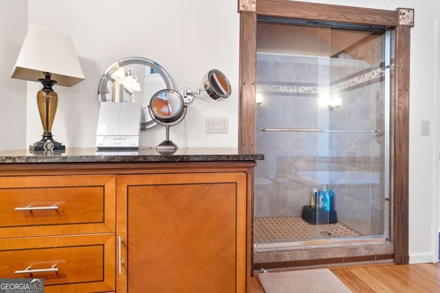 bathroom featuring hardwood / wood-style floors and walk in shower