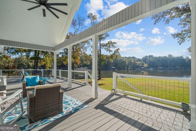 wooden terrace featuring a lawn, ceiling fan, and a water view