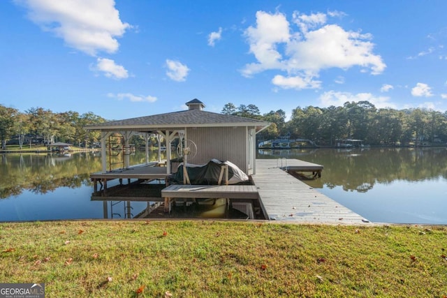 view of dock featuring a water view and a yard